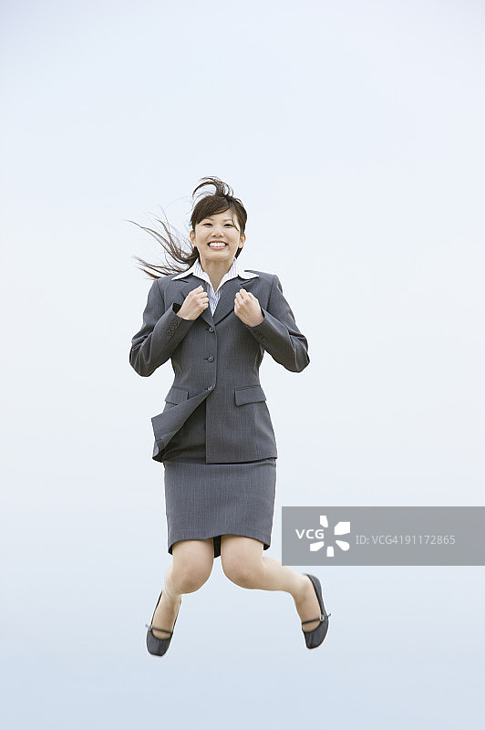 女商人跳跃，紧握拳头图片素材