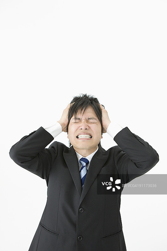 双手抱头，闭着眼睛的商人图片素材