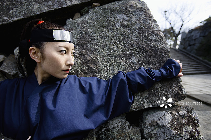 隐藏在石墙后面的女忍者图片素材