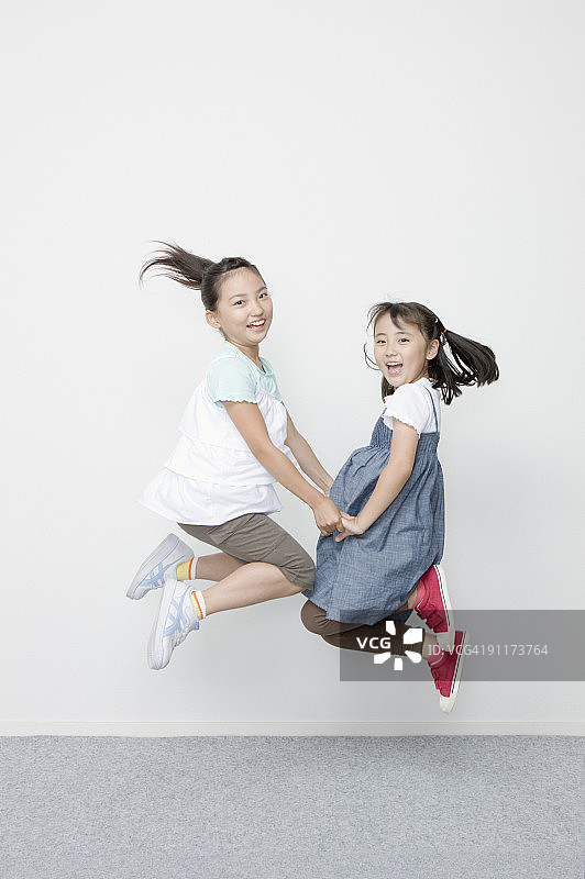 手牵手跳跃的女孩们图片素材
