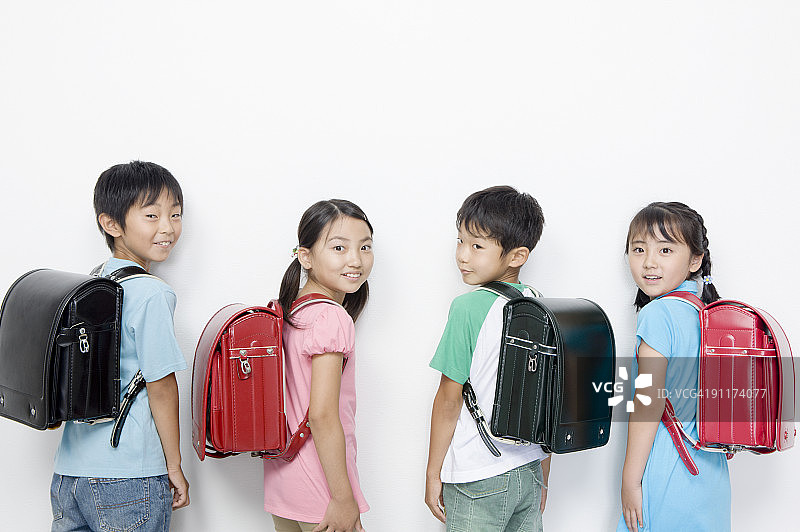 背着书包回头的男孩和女孩图片素材