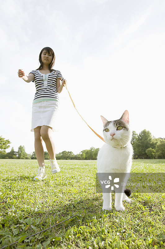女孩在公园里遛猫图片素材