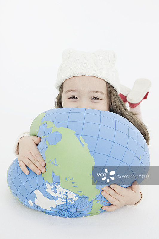 手持地球形状靠垫的女孩图片素材