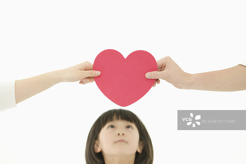 两人在女孩上方托起一颗心图片素材