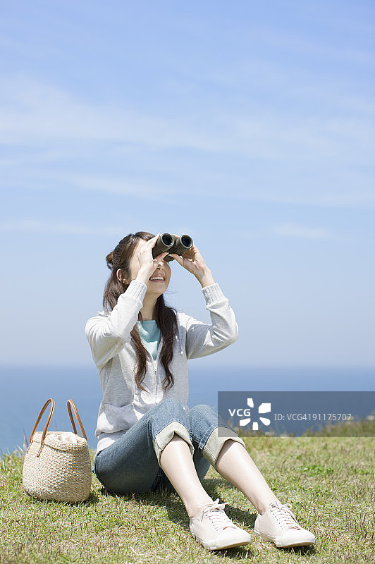 用双筒望远镜看的年轻女人图片素材