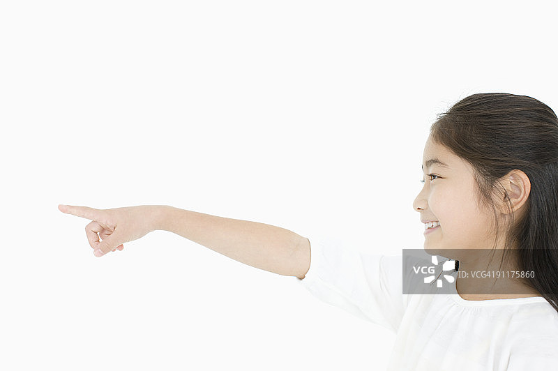 女孩指向前方，侧视图，工作室拍摄图片素材