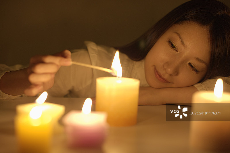 女人点燃蜡烛图片素材