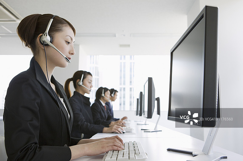 戴着耳机使用电脑的商人图片素材