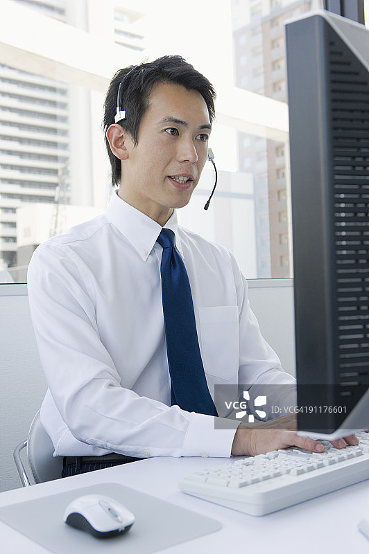 戴着耳机的商务人士使用电脑图片素材