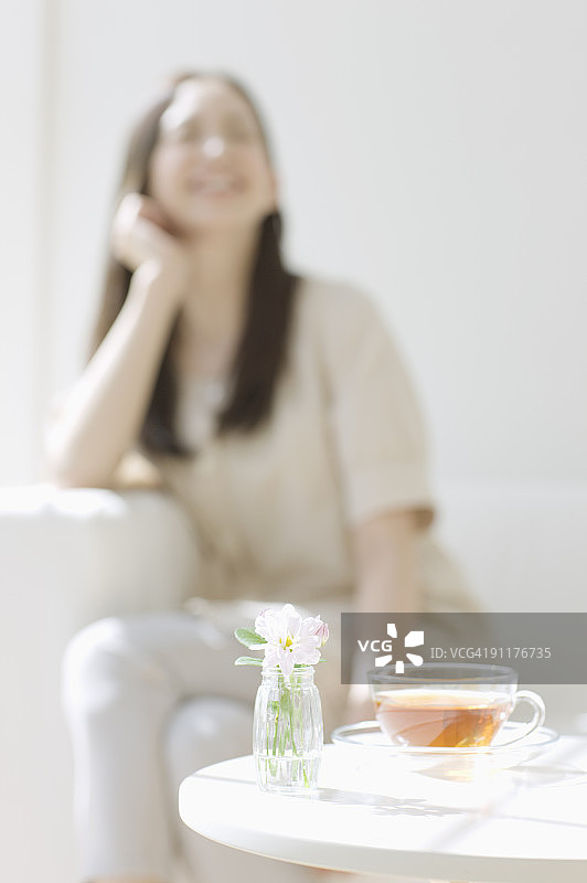 女人坐在沙发上，焦点在前图片素材