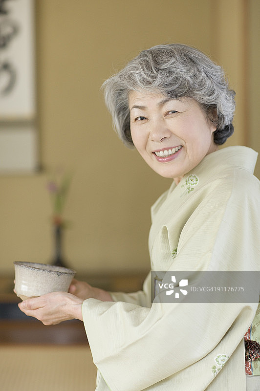 身穿和服手持日式茶杯的年长女性图片素材