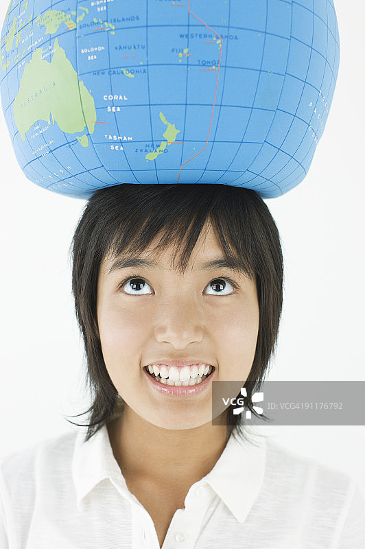 头顶地球仪的女孩，影棚拍摄图片素材