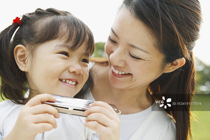 女人和女孩拿着口琴，微笑图片素材