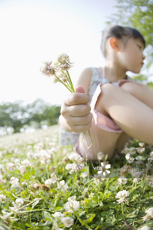 女孩拿着鲜花，前景聚焦图片素材