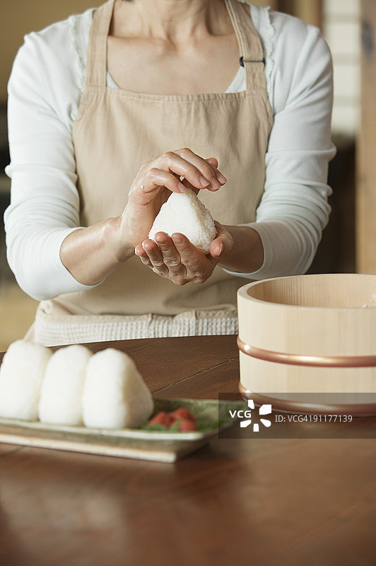 制作饭团的中年妇女（局部）图片素材