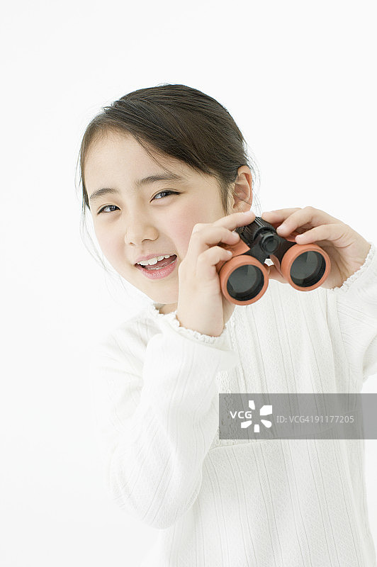 手持双筒望远镜的女孩（影棚拍摄）图片素材
