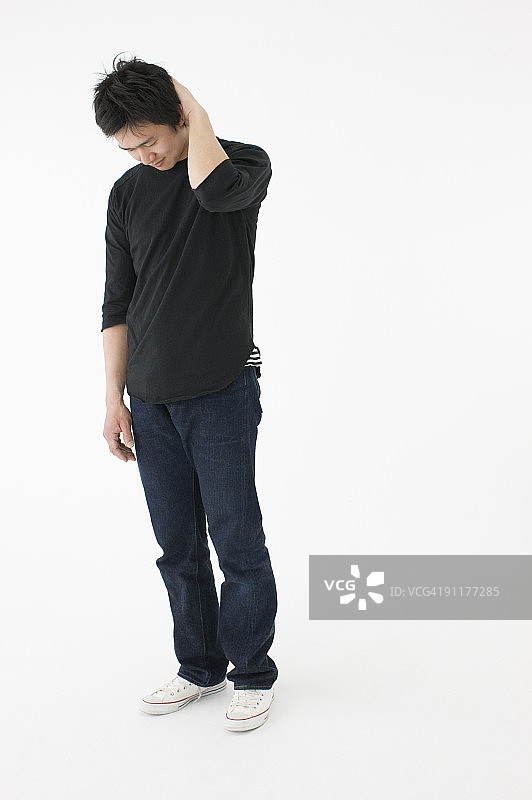 男人手放在脑后向下看，工作室拍摄图片素材