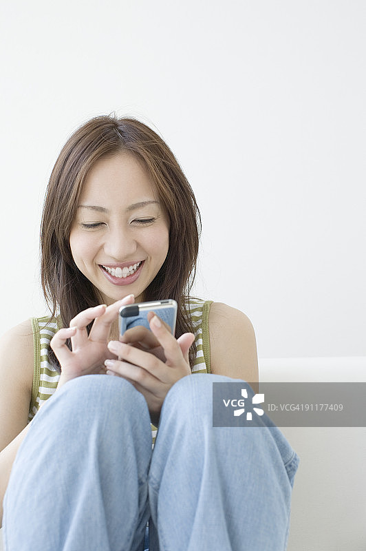 女人使用手机，面带微笑图片素材
