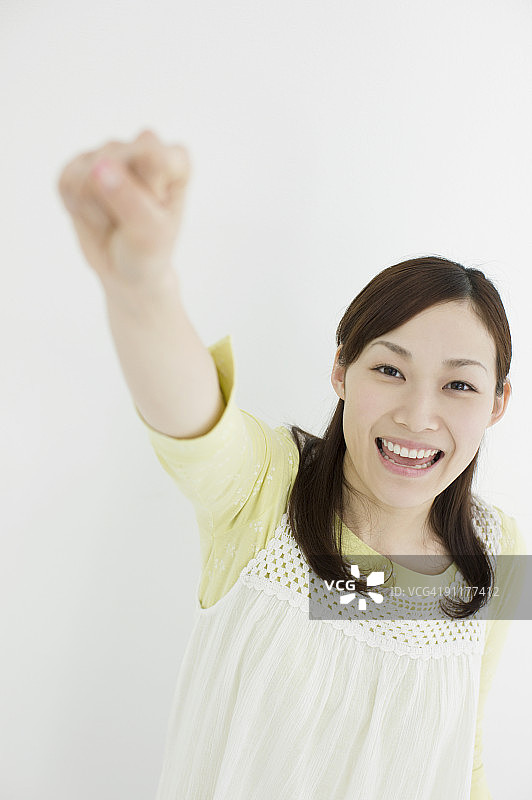年轻女子举起拳头，肖像图片素材