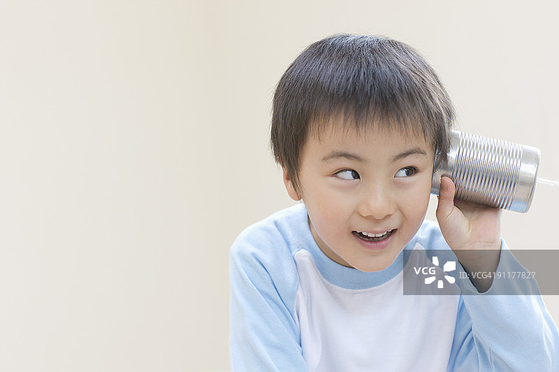 玩着罐头电话的男孩图片素材