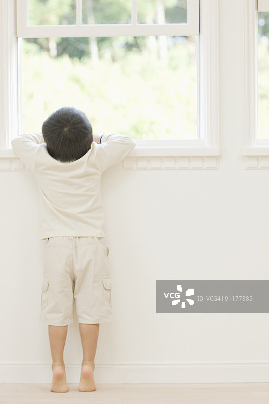 男孩向窗外看，后视图图片素材