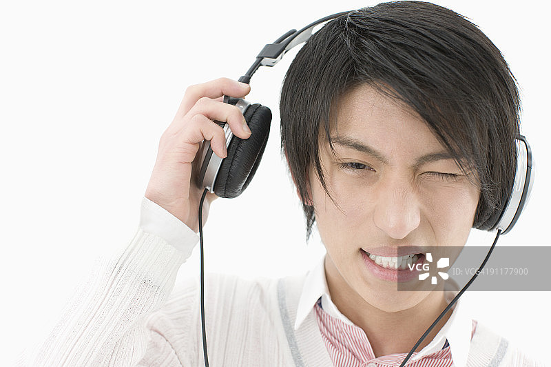年轻男人摘下耳机，工作室拍摄图片素材