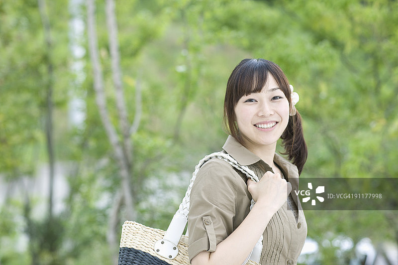 拿着包微笑的女人图片素材