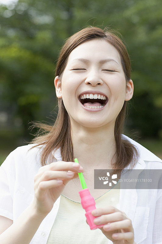 闭眼微笑吹泡泡的女人图片素材