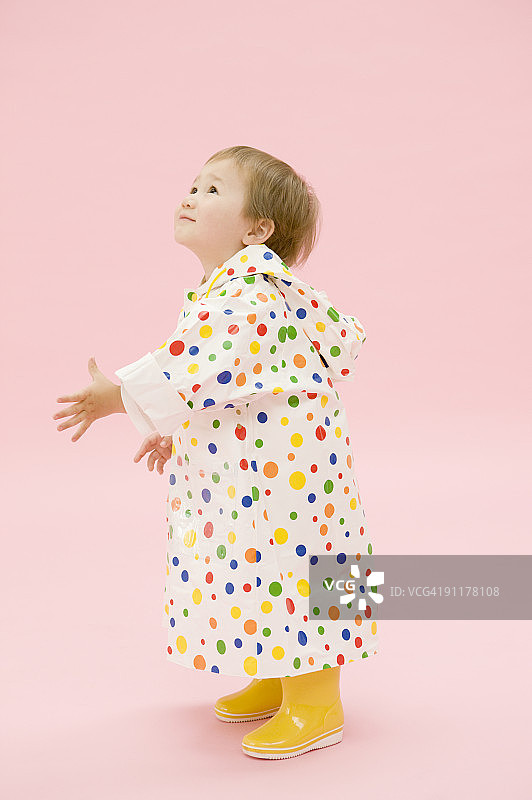 男孩穿着雨衣和橡胶靴，影棚拍摄图片素材