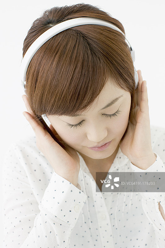 戴着耳机在录音棚里听音乐的女人图片素材