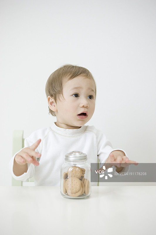 男孩拿着罐子里的饼干图片素材