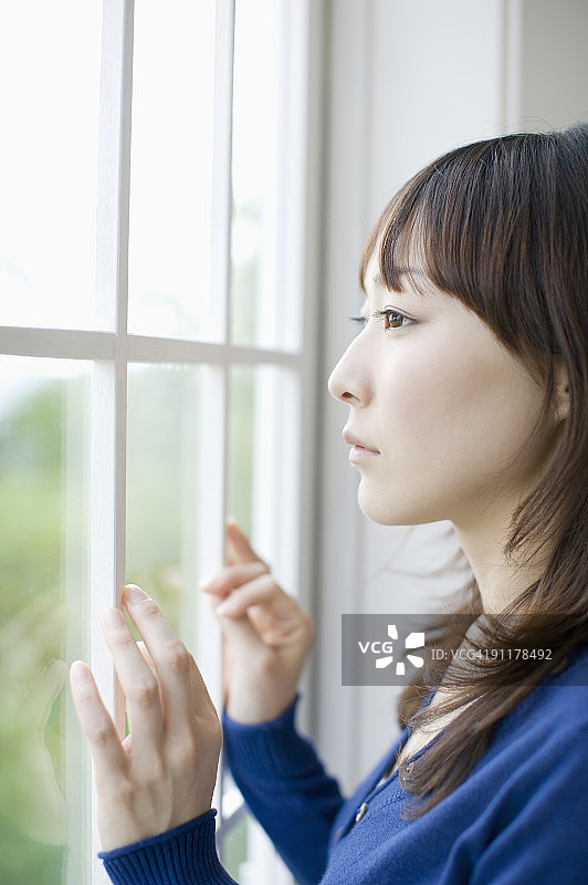 女人侧身向窗外看图片素材