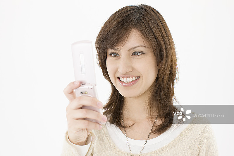 使用手机微笑的年轻女人图片素材