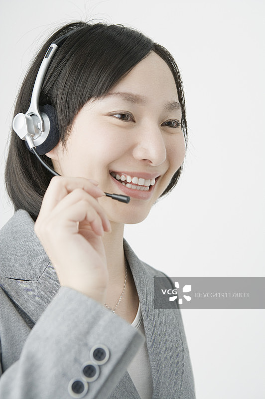 戴着耳机微笑的女商人图片素材