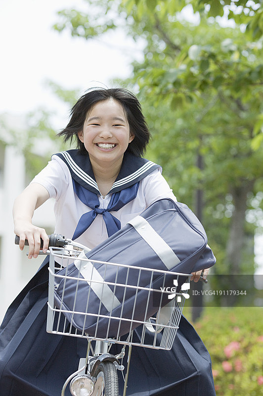 女学生骑自行车，面带微笑图片素材