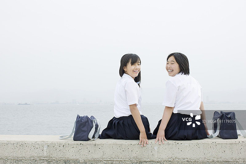 女学生坐在堤坝上图片素材