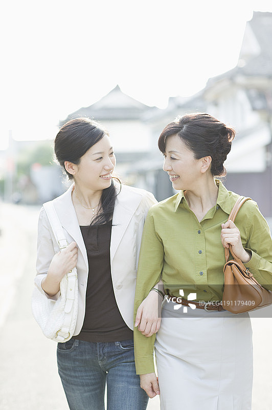 手挽着手，微笑的女人图片素材