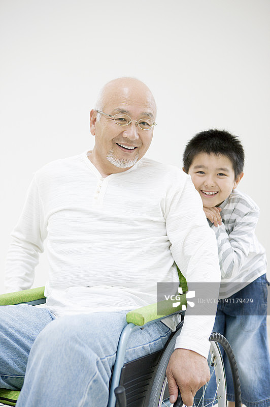 坐在轮椅上的男孩和祖父图片素材