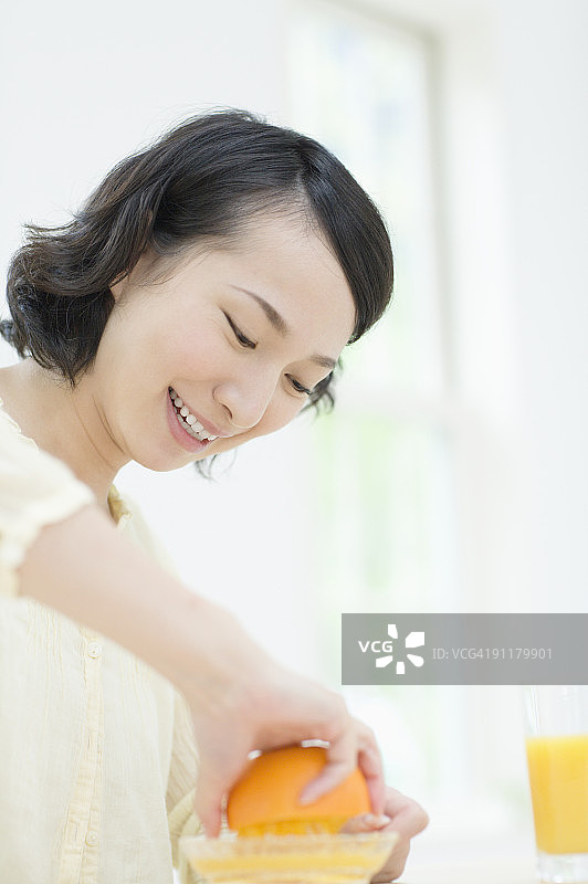 榨橙汁的年轻女人图片素材