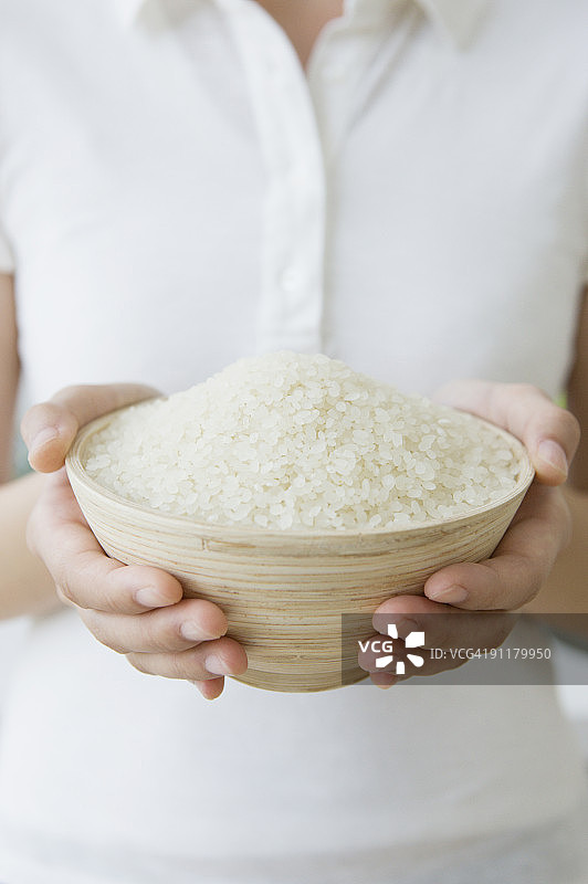 年轻女人手捧米饭碗（半身照）图片素材