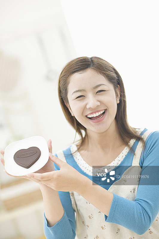 年轻女人手持心形巧克力图片素材