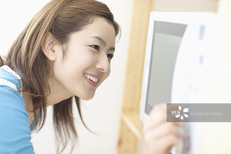 用微波炉烹饪的年轻女人图片素材
