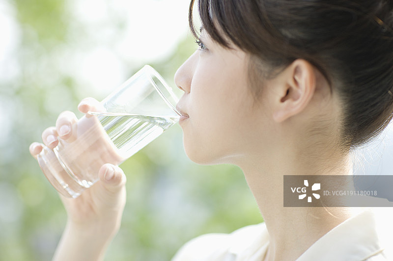 年轻女人喝水侧面照图片素材