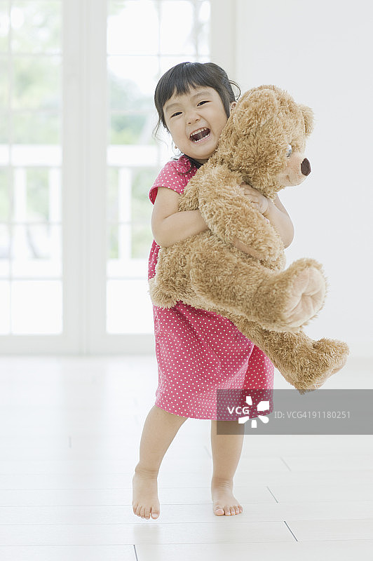 面带微笑手抱泰迪熊的女孩图片素材