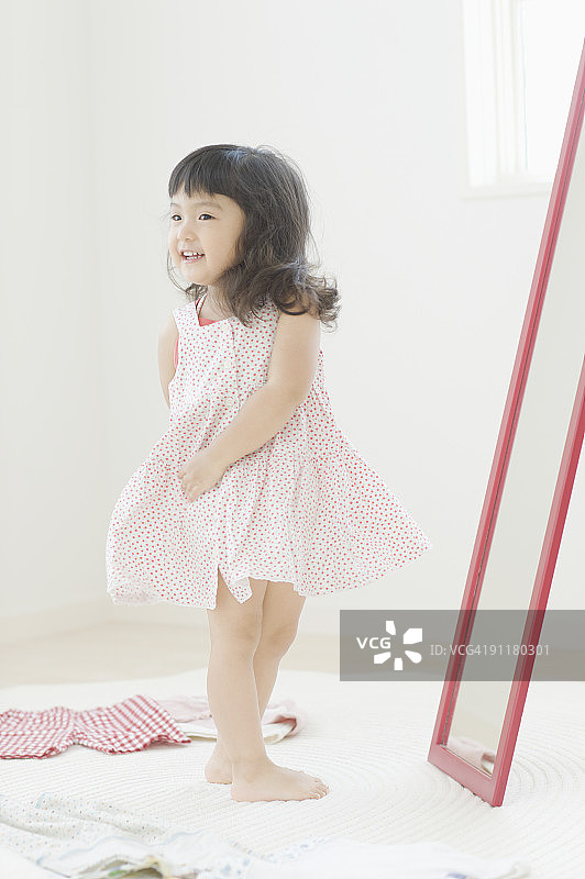 女孩在镜子前穿连衣裙图片素材