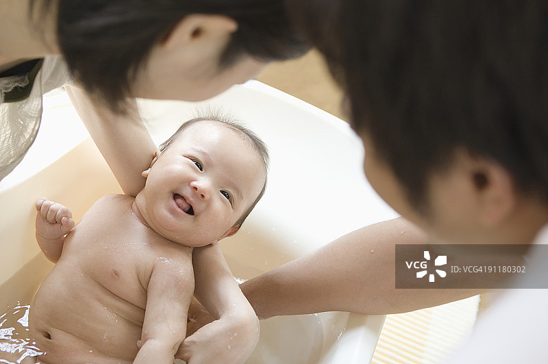 父母给男婴洗澡图片素材