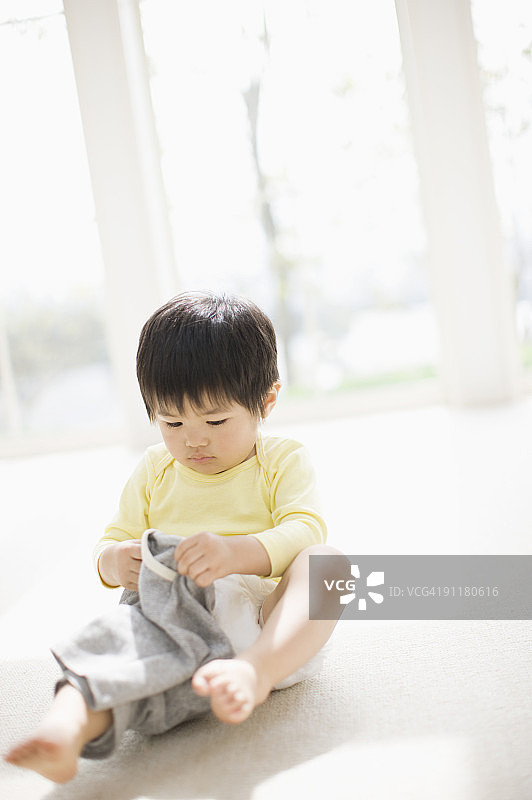 男孩试图穿上裤子图片素材