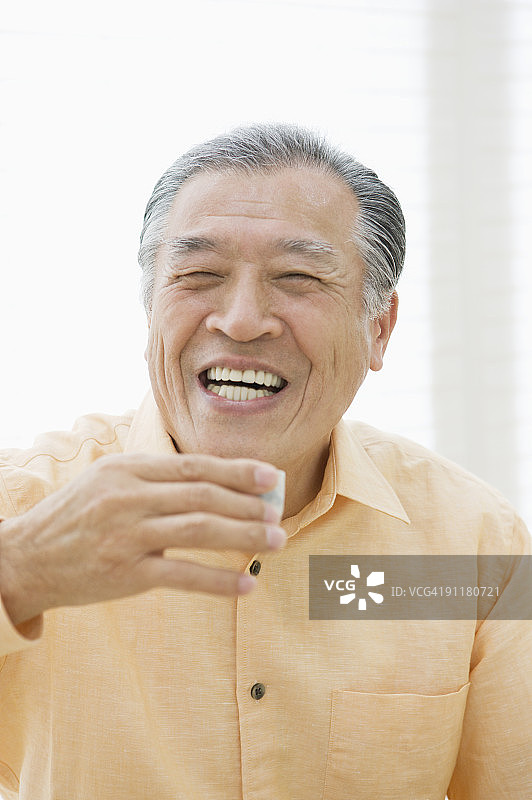 手持清酒的年长男人特写肖像图片素材