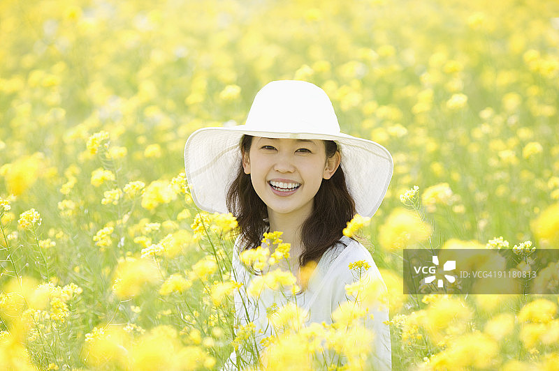 油菜籽田里的年轻女子肖像图片素材