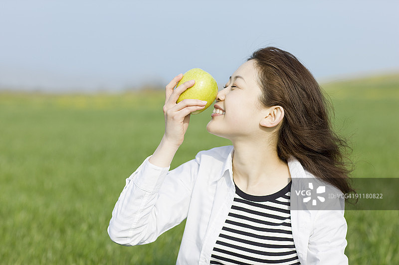 年轻女人拿着一个青苹果图片素材